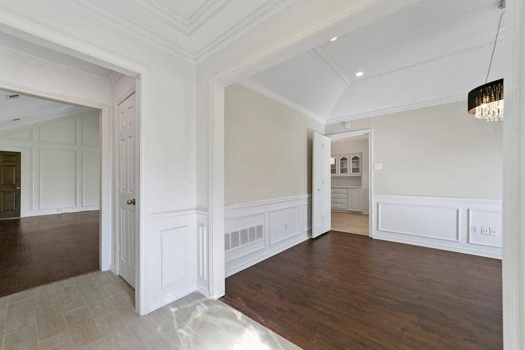 16353 Lauder Lane, Dallas, TX 75248 Vaulted ceiling with crown molding, wainscoting, wood-finish flooring, and a decorative light fixture