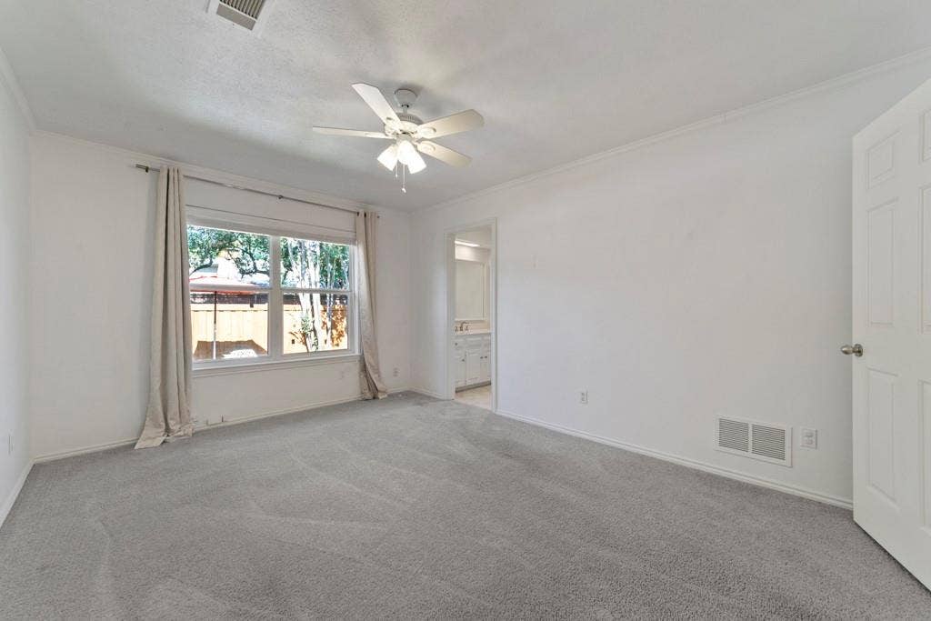 16353 Lauder Lane, Dallas, TX 75248 Carpeted room with a ceiling fan, a window, and white walls