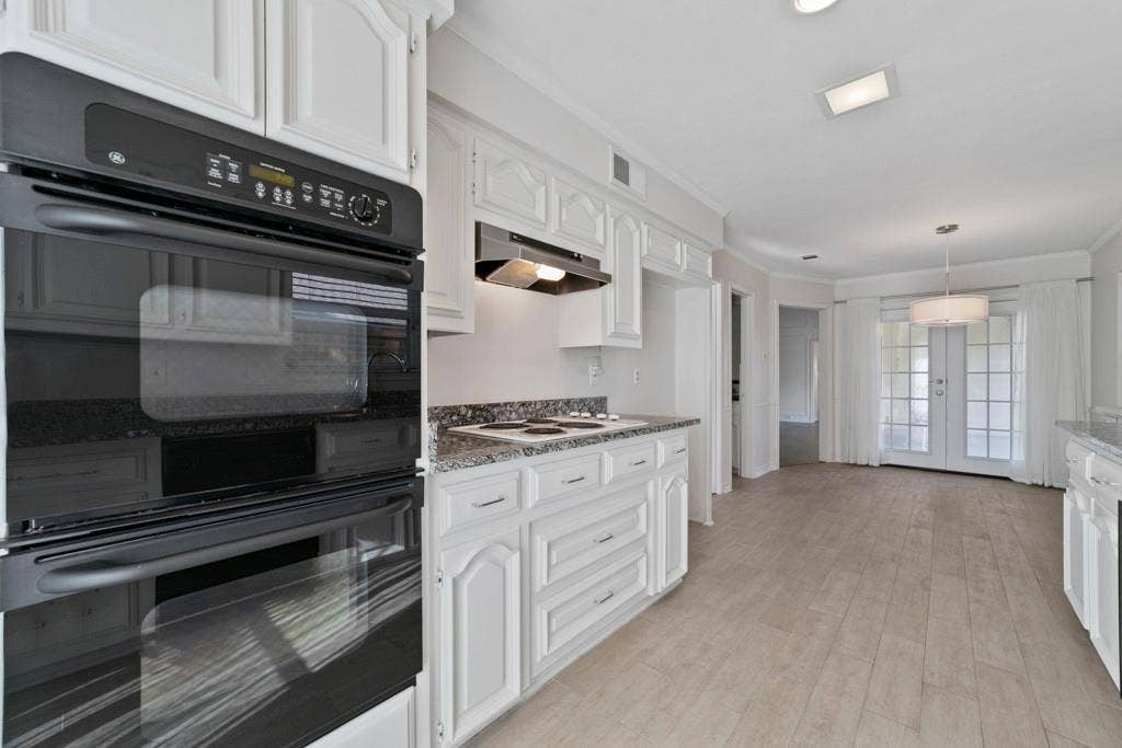 16353 Lauder Lane, Dallas, TX 75248 White cabinetry with dark hardware, built-in double oven, and granite-style countertops