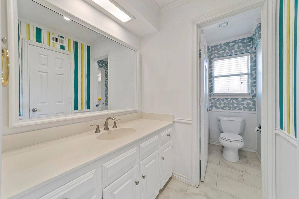 16353 Lauder Lane, Dallas, TX 75248 Elongated vanity with integrated sink, brushed nickel faucet, and paneled cabinetry