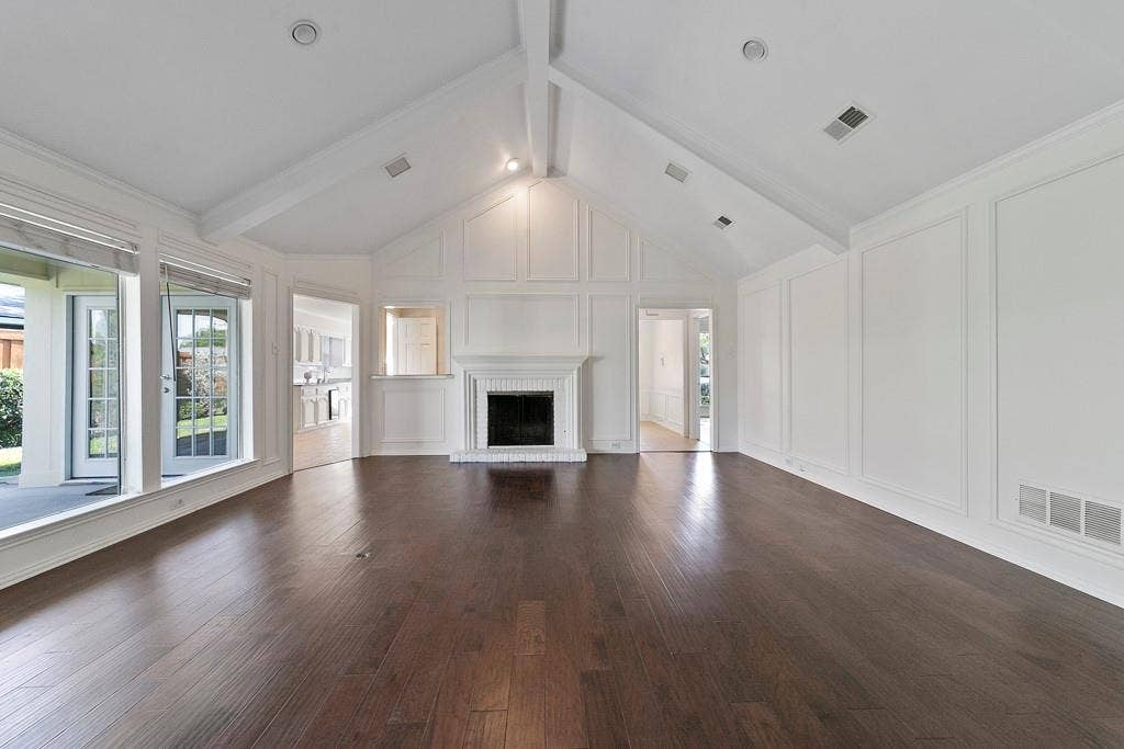 16353 Lauder Lane, Dallas, TX 75248 Vaulted ceiling with exposed beams, dark wood-finish flooring, white fireplace with hearth, and French doors