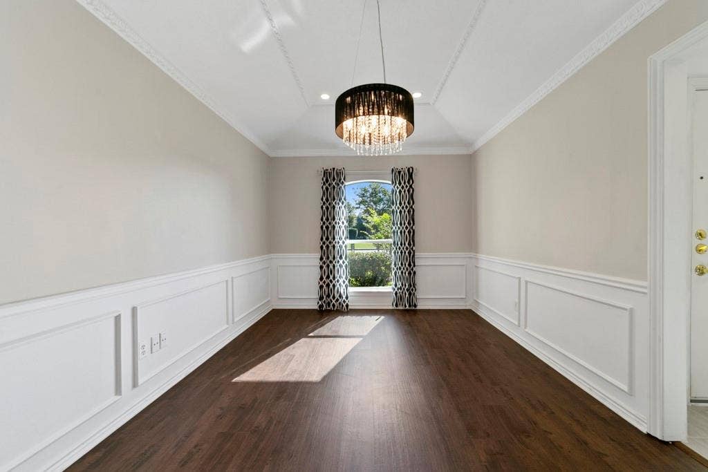 16353 Lauder Lane, Dallas, TX 75248 Wood-finish flooring with wainscoting, a crystal chandelier, crown molding, and a vaulted ceiling