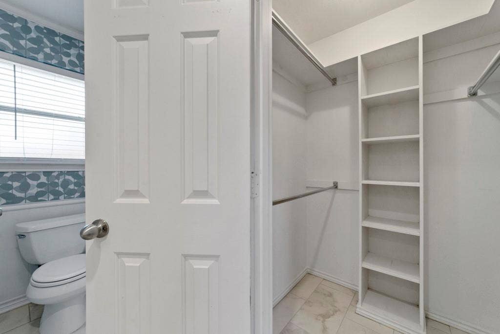 16353 Lauder Lane, Dallas, TX 75248 Walk-in closet with built-in shelving, two hanging rods, and light-toned flooring