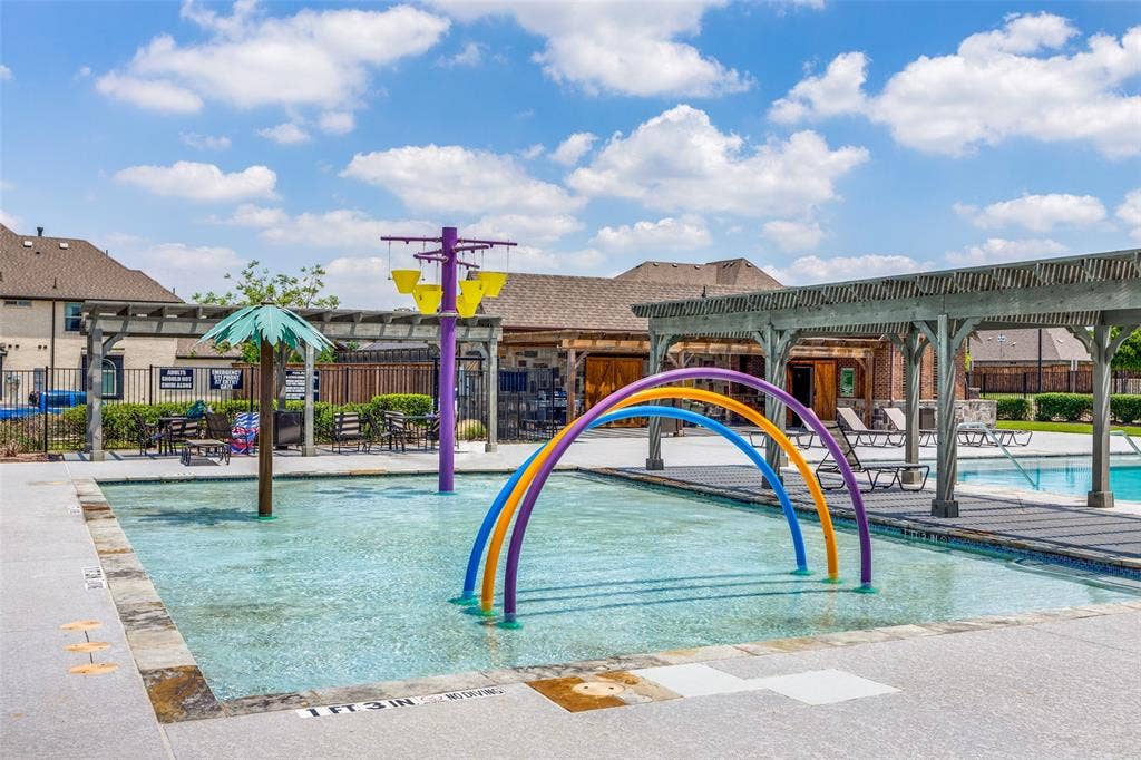 1481 Ramsbury Lane, Prosper, TX 75078 Community splash pad with multiple water features, adjacent to a swimming pool and covered pergola