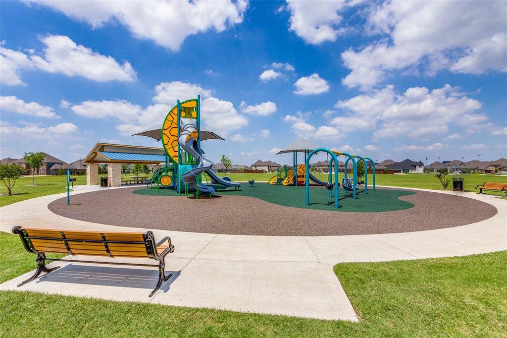1481 Ramsbury Lane, Prosper, TX 75078 Community playground featuring multiple slides, swing sets, a covered picnic area, and a paved pathway