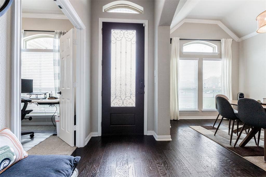 1481 Ramsbury Lane, Prosper, TX 75078 Dark wood-finish flooring throughout, decorative glass entry door with an arched transom, and vaulted ceiling details