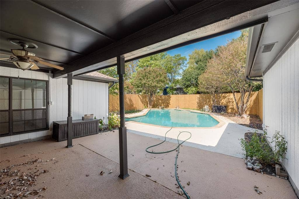 1903 Clemson Drive, Richardson, TX 75081 Covered patio with a ceiling fan, leading to a fenced backyard featuring an in-ground swimming pool and mature trees