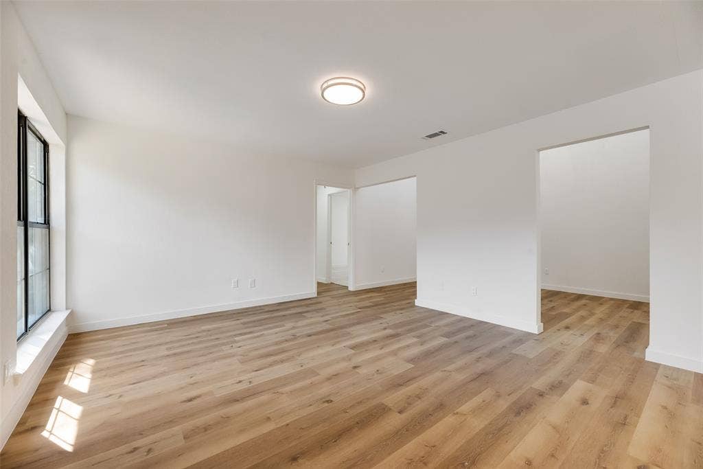 1903 Clemson Drive, Richardson, TX 75081 Recessed ceiling light, white walls, wood-finish flooring, black window frames, and open doorways