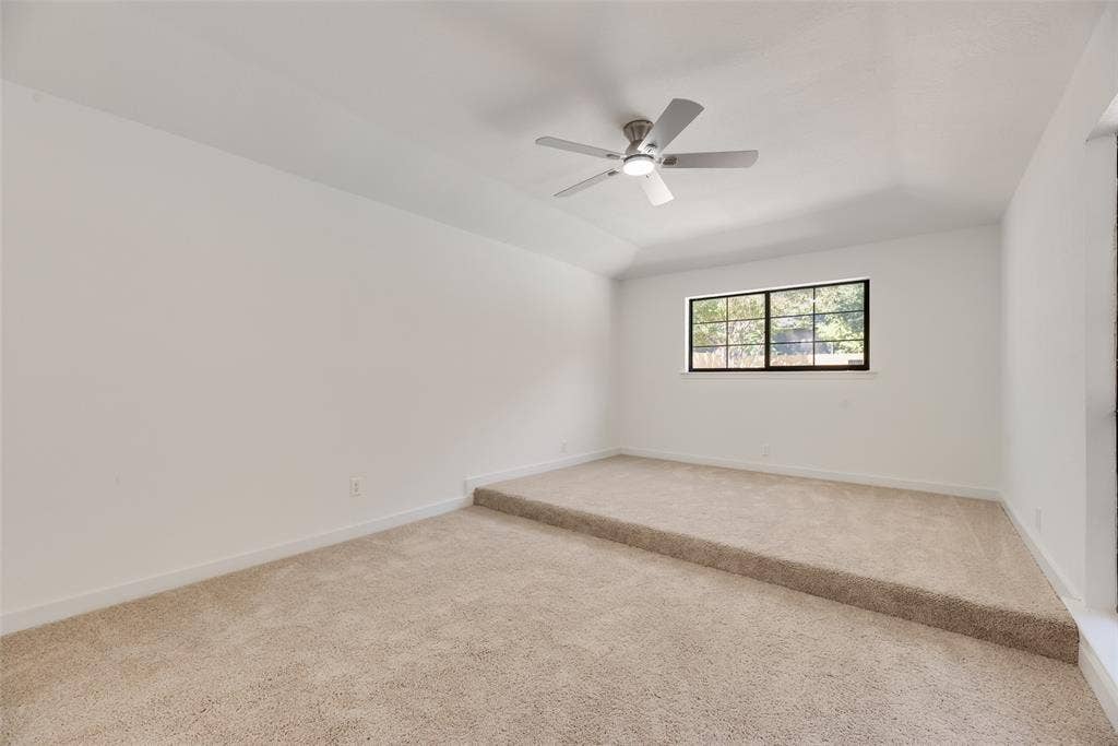 1903 Clemson Drive, Richardson, TX 75081 Vaulted ceiling with an installed ceiling fan, neutral wall paint, and beige carpet