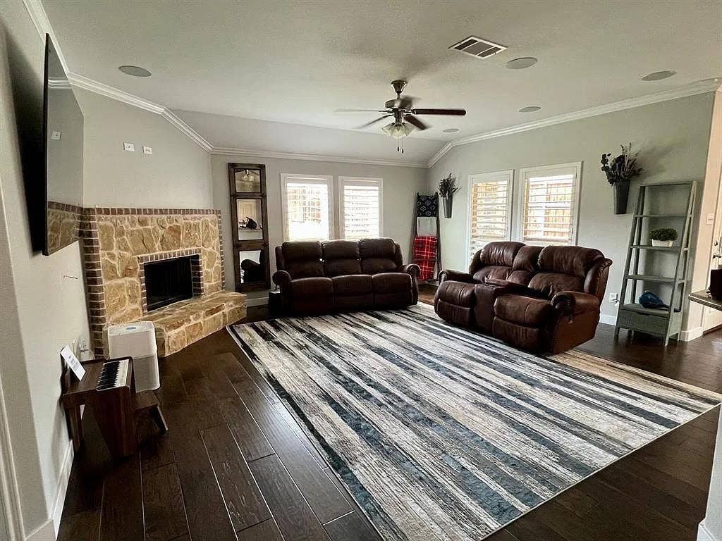 15009 Northview Drive, Little Elm, TX 75068 Spacious living area featuring a stone and brick fireplace, vaulted ceiling with a ceiling fan, and dark wood-finish flooring