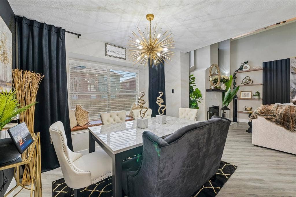 Open-concept interior featuring light wood-finish flooring, a contemporary sputnik chandelier, and a built-in window bench
