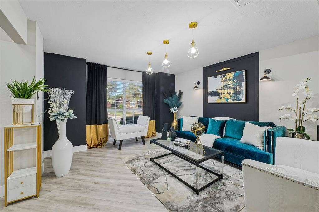 Wood-finish flooring, accent wall with paneling, recessed lighting, and modern pendant light fixtures
