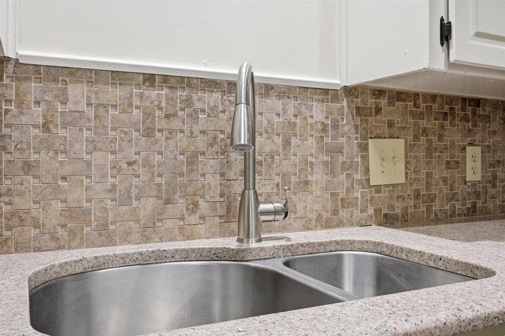 Dual basin stainless steel sink with a high-arc pull-down faucet