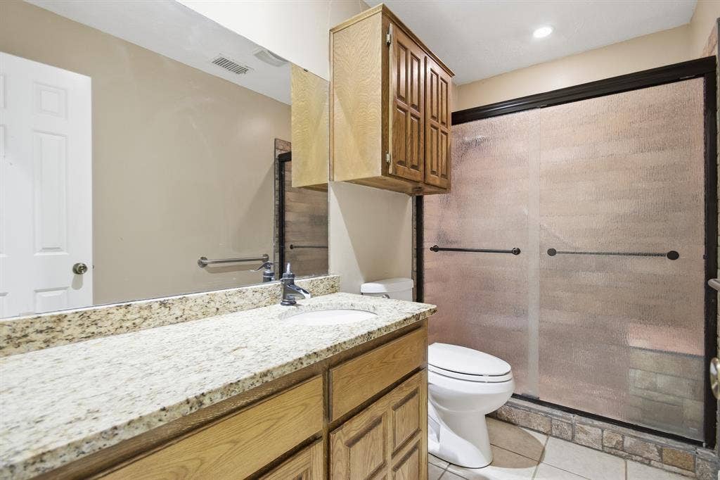 Master bathroom featuring dual vanity with granite countertop, undermount sink, and matte black faucet hardware