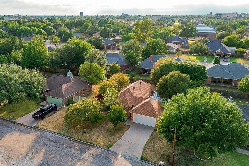 Single-story residence with a brown shingle roof, attached garage, and a concrete driveway