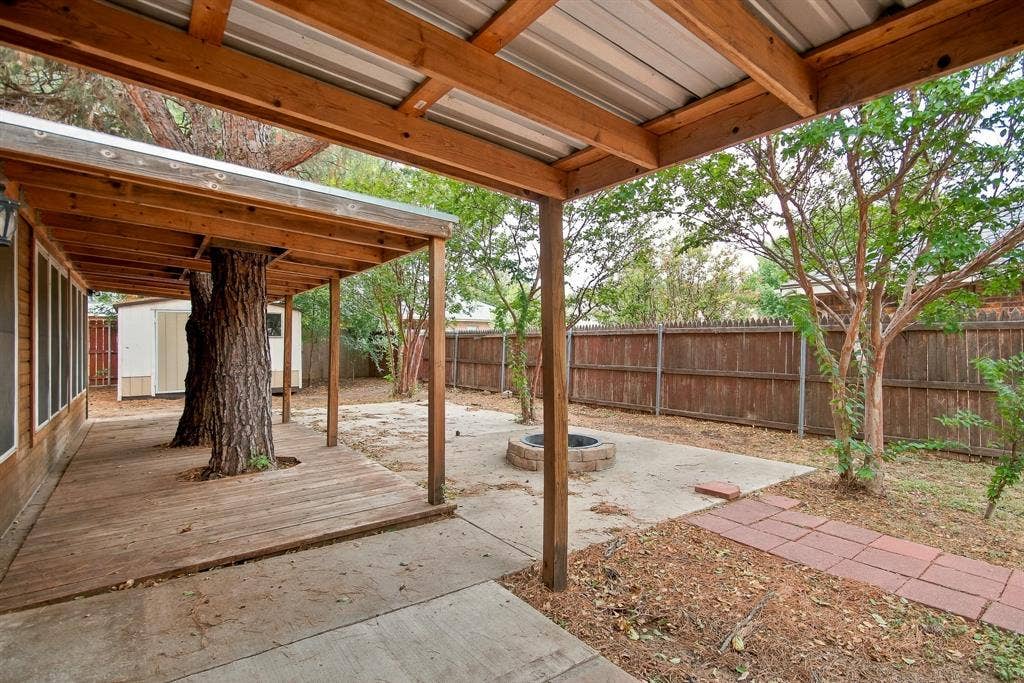 Covered outdoor living space with exposed wood beams and a metal roof
