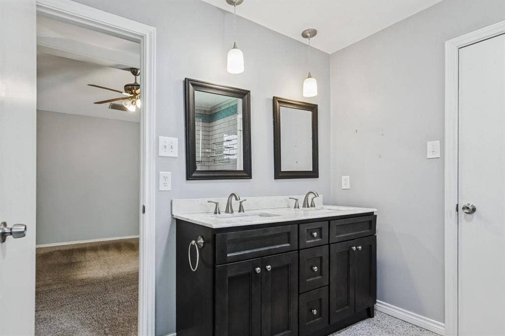 Dual vanity with white countertop, dark wood-finish cabinetry, and brushed nickel hardware