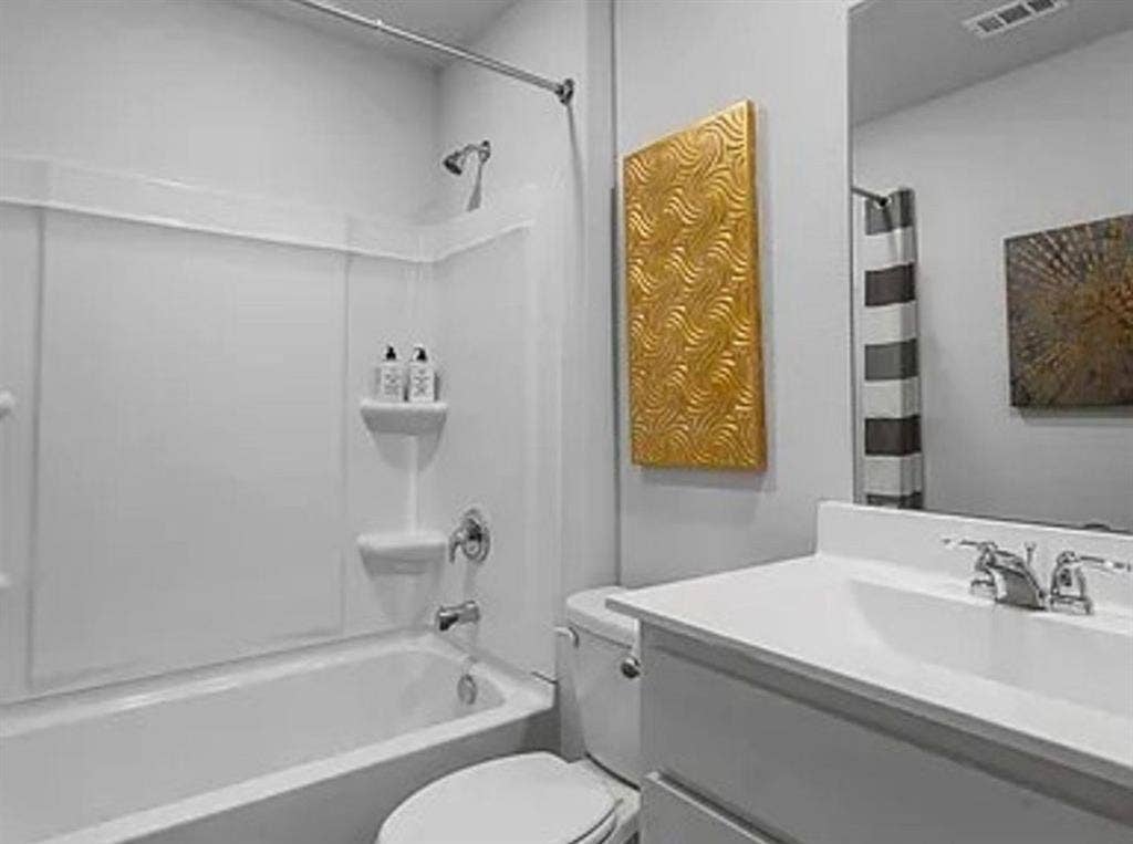 Bathroom featuring shower / bath combo with shower curtain and vanity