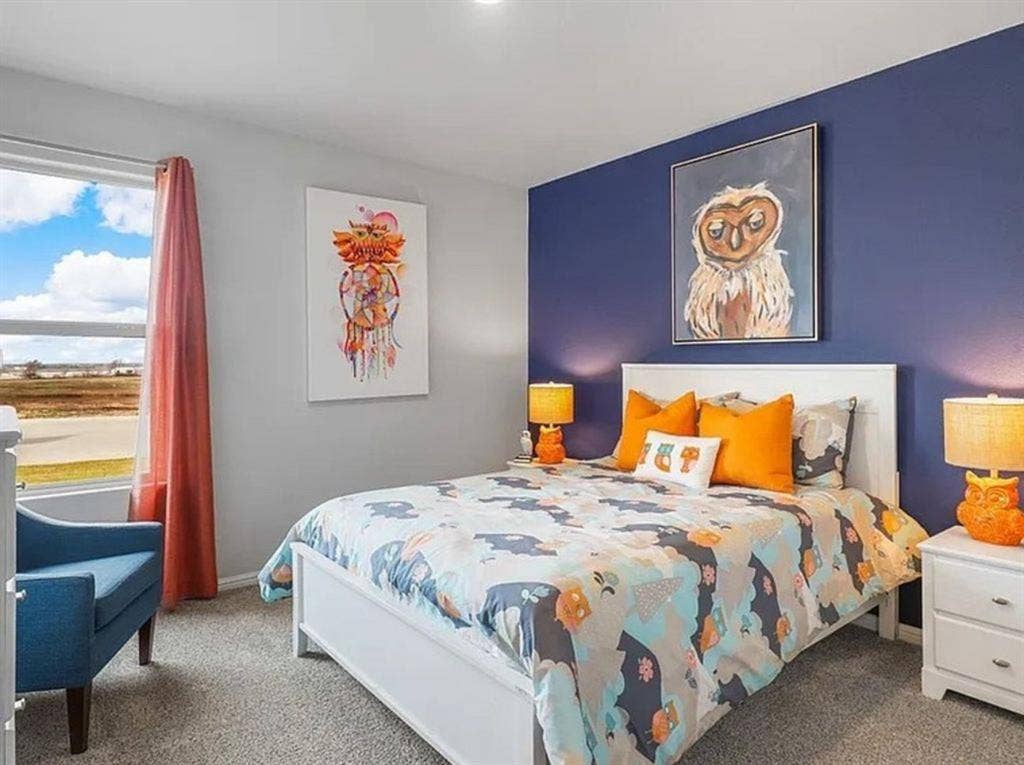 Staged Carpeted bedroom featuring baseboards. Home is vacant and this room no longer has the accent wall color.