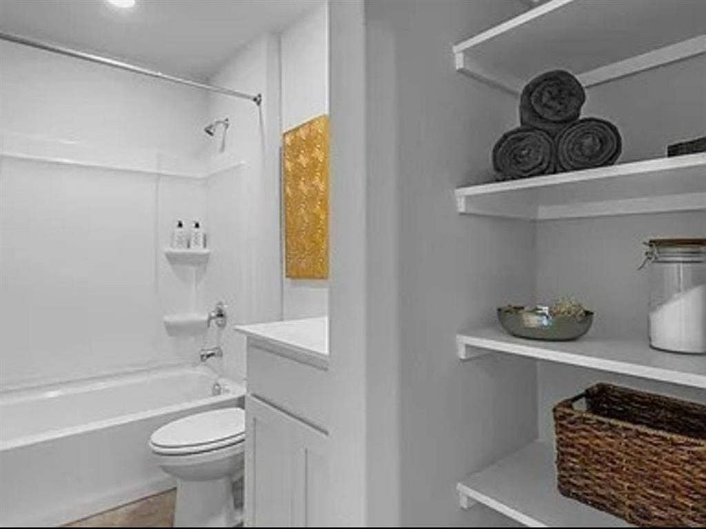 Bathroom with shower / tub combination, vanity, and dark tile patterned floors