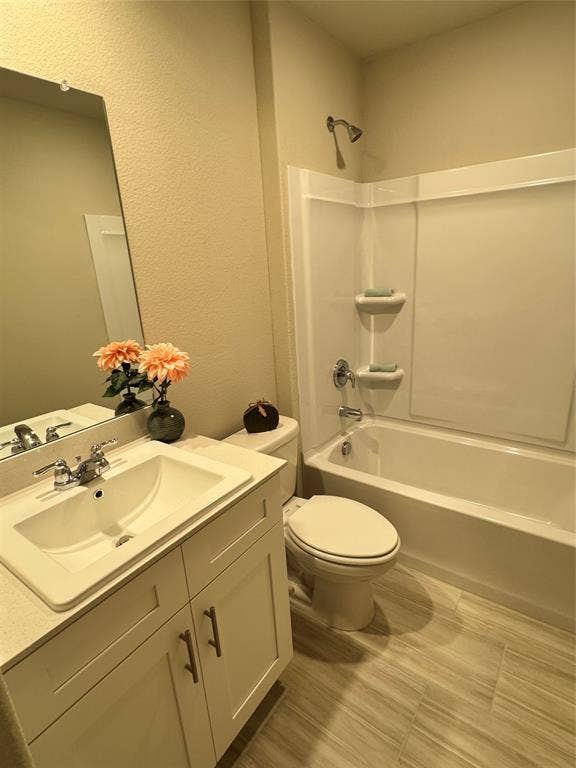 Bathroom with vanity, a textured wall, and  shower combination