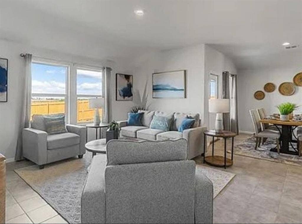 Staged Living room featuring healthy amount of natural light, light tile patterned floors, and recessed lighting