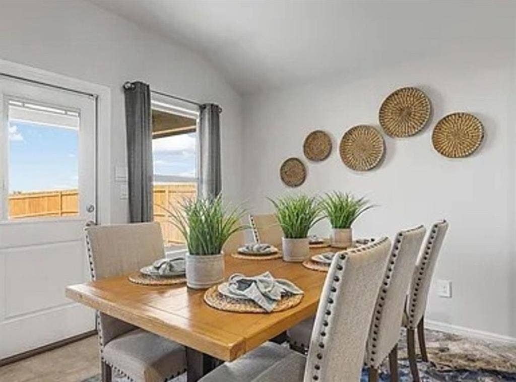 Staged Dining area with vaulted ceiling and baseboards Home is currently vacant.