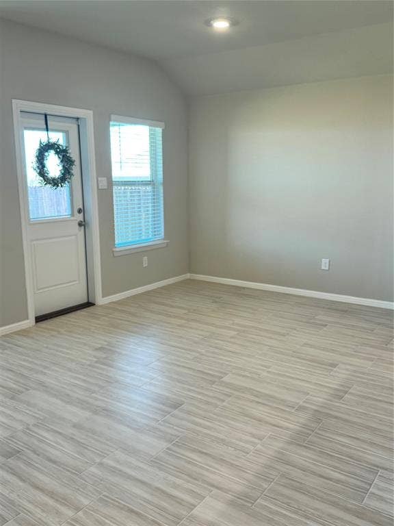 Foyer featuring vaulted ceiling and wood tiled floors
