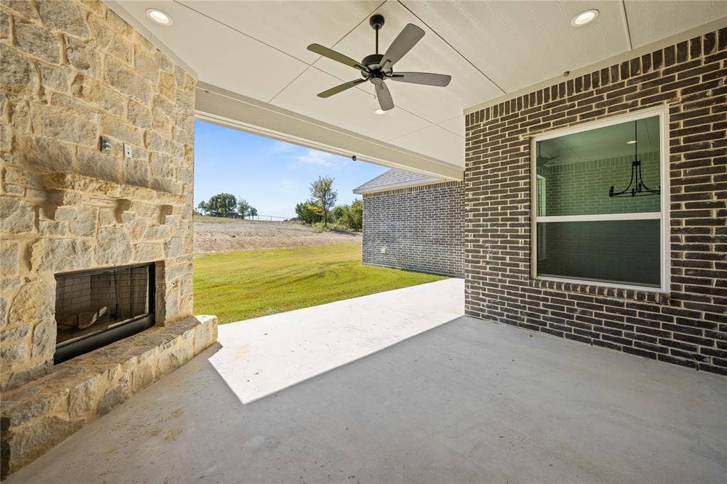 104 Oak Meadow Lane, Weatherford, TX 76085 Covered outdoor patio featuring a stone fireplace, ceiling fan, recessed lighting, and expansive concrete flooring