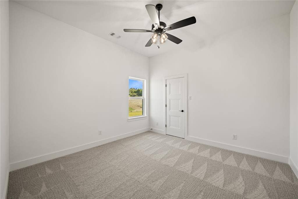 104 Oak Meadow Lane, Weatherford, TX 76085 Neutral tone wall paint, patterned carpet flooring, white trim, single window, and a ceiling fan with light fixture