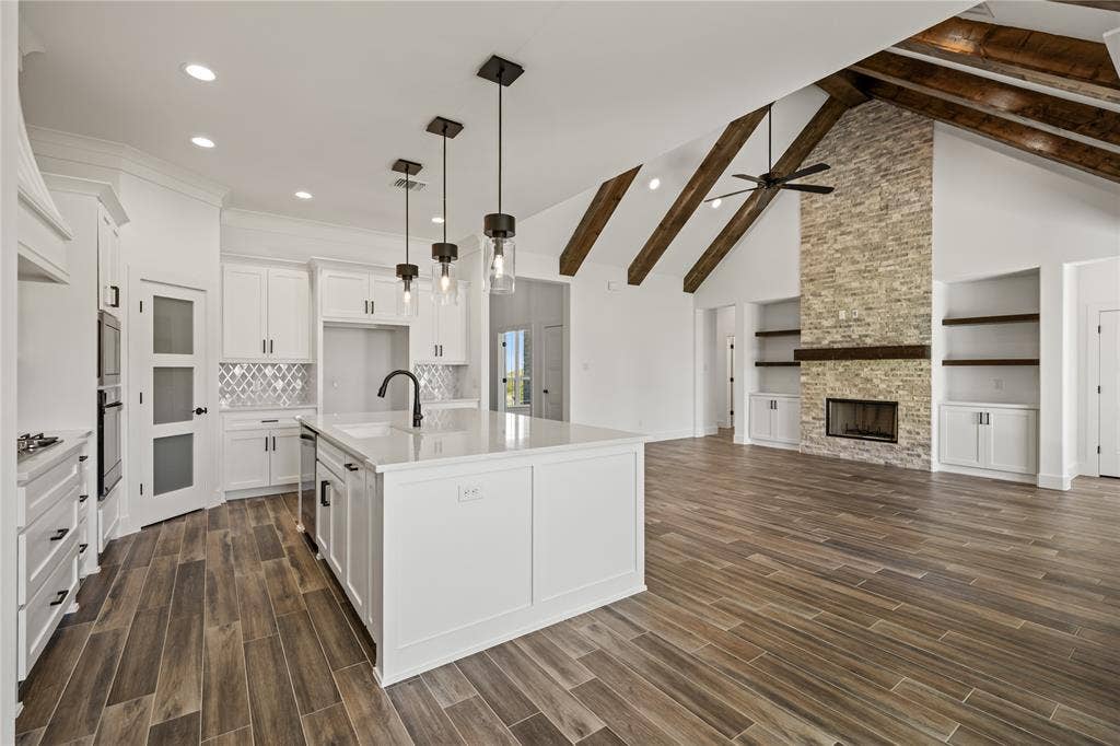 104 Oak Meadow Lane, Weatherford, TX 76085 Gourmet kitchen with white cabinetry and quartz countertops, featuring a large center island and modern pendant lighting