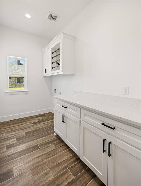 104 Oak Meadow Lane, Weatherford, TX 76085 White shaker-style cabinetry with matte black hardware, white countertop, wood-finish flooring, and a built-in drying rack