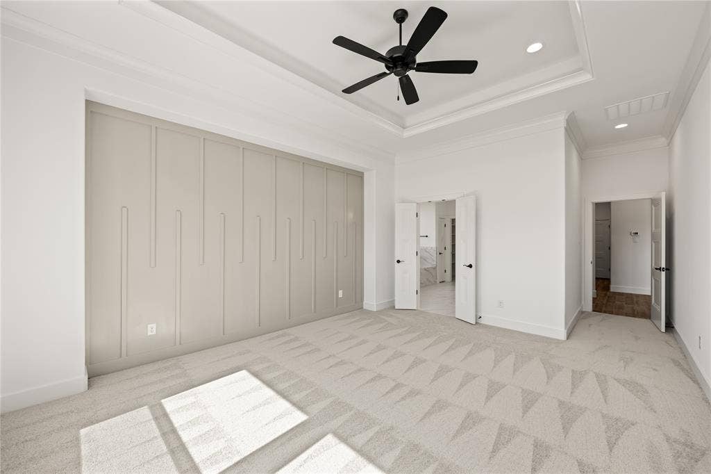 104 Oak Meadow Lane, Weatherford, TX 76085 Tray ceiling with recessed lighting and a ceiling fan, geometric pattern accent wall, and patterned carpet flooring
