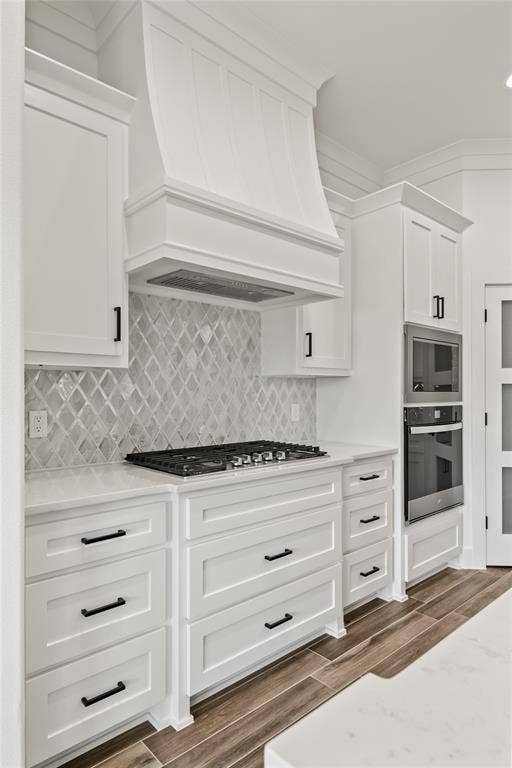 104 Oak Meadow Lane, Weatherford, TX 76085 White shaker cabinetry with black hardware, gas cooktop, built-in double ovens, and wood-finish flooring