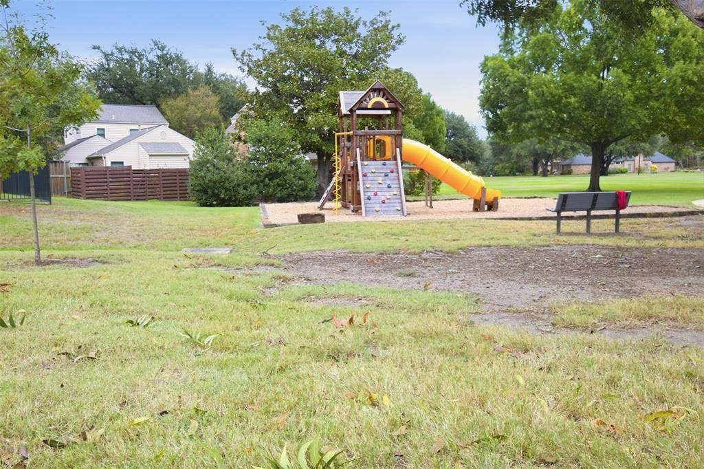 Playground with a slide, climbing wall, and bench seating