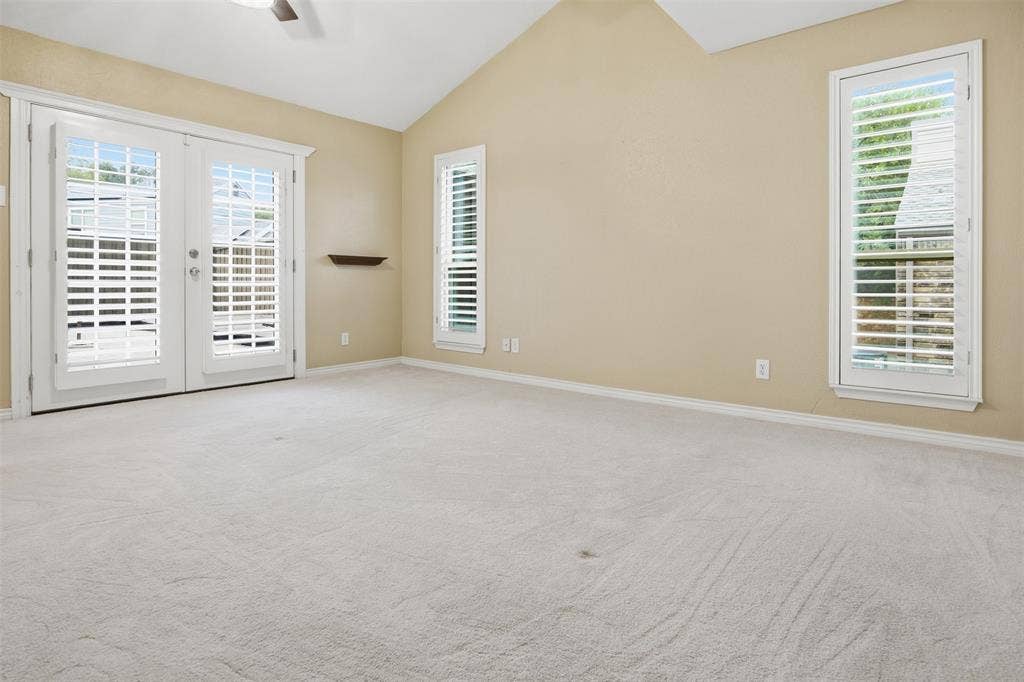 Vaulted ceiling, ceiling fan, carpet flooring, plantation shutters, French doors