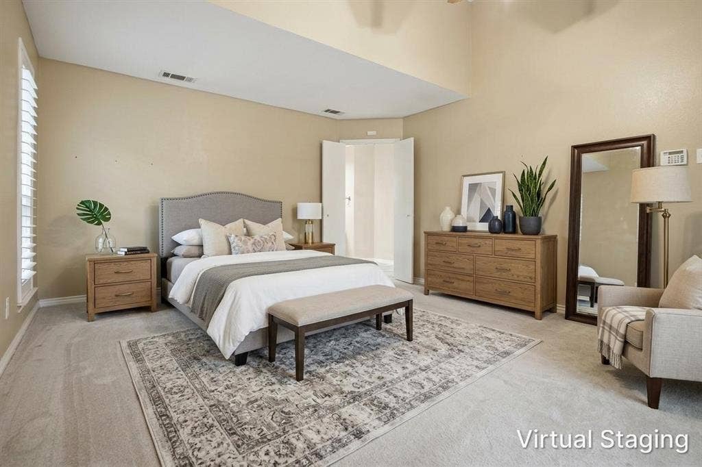 Vaulted ceilings, neutral wall tones, and light-colored carpeting