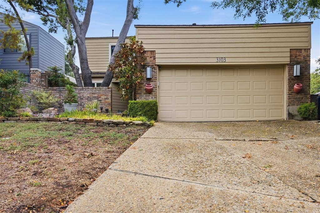 Brick and siding exterior with a panel garage door