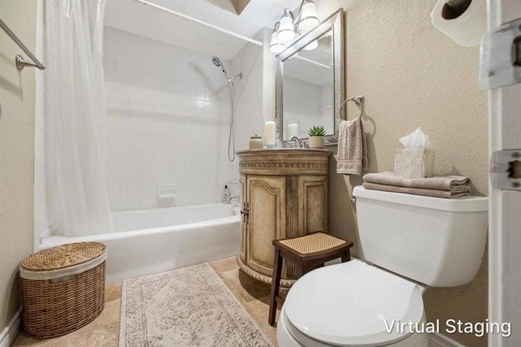 White subway tile bath surround, white tub, decorative vanity with an integrated sink, vanity mirror, and three-light vanity fixture