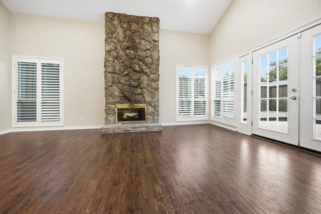 Vaulted ceiling with a stone-clad fireplace and brass-tone insert
