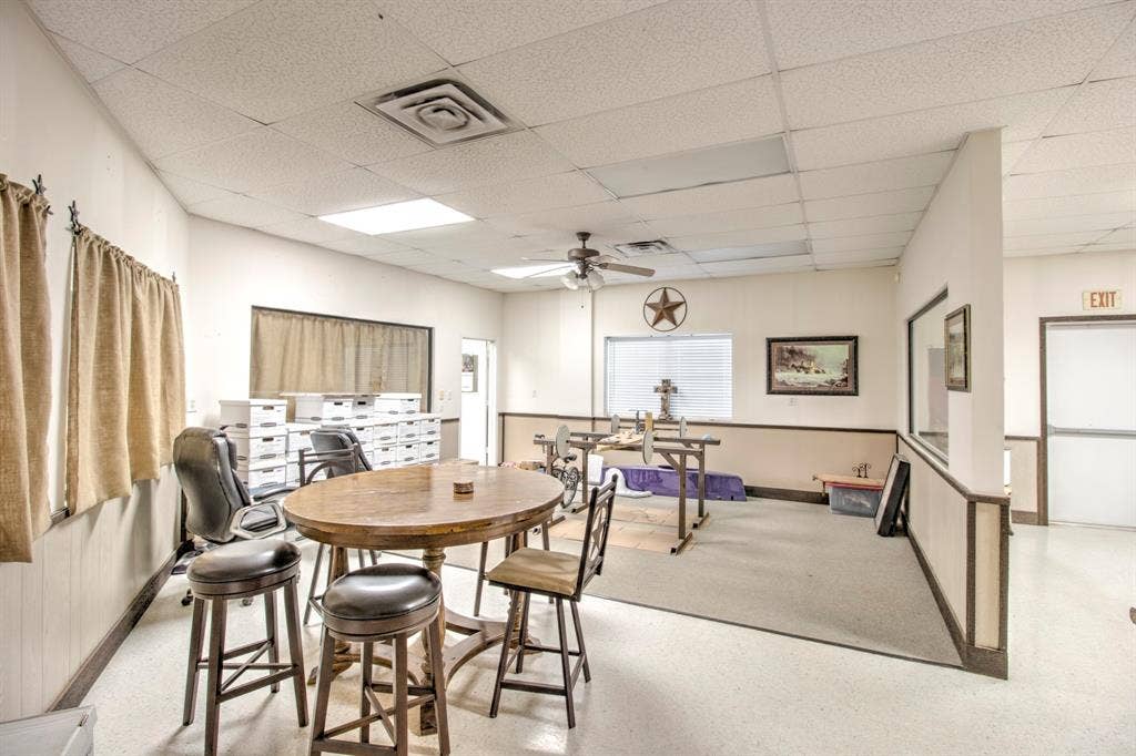 Multi-purpose room featuring a drop ceiling, inset fluorescent lighting, neutral wall-to-wall carpeting, and chair rail molding