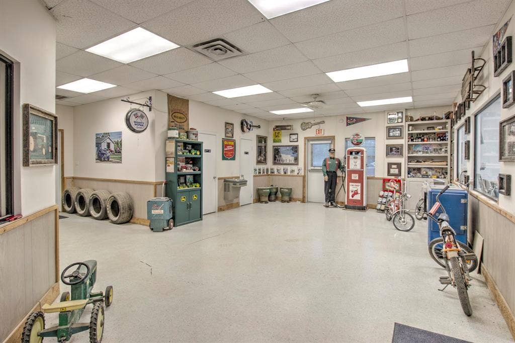 Expansive interior featuring high-visibility recessed lighting, durable solid-surface flooring, wainscoting throughout, and built-in wall shelving