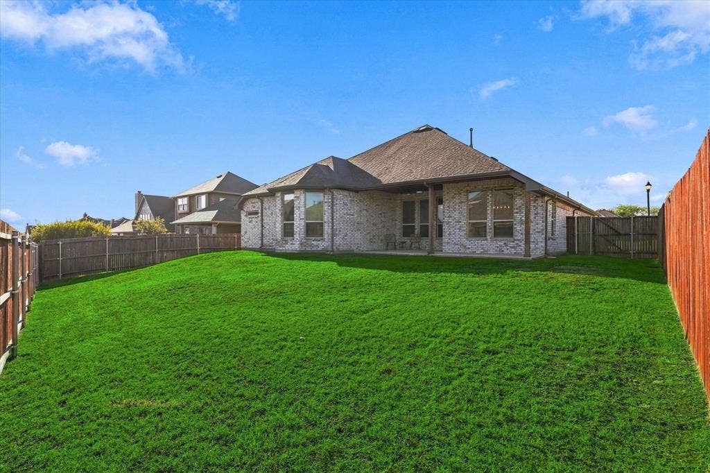 Expansive backyard with a sloped, manicured lawn