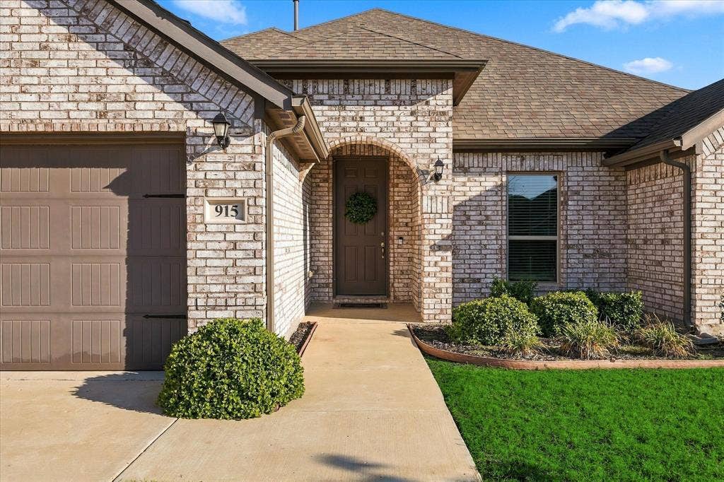 White brick exterior with a brown garage door