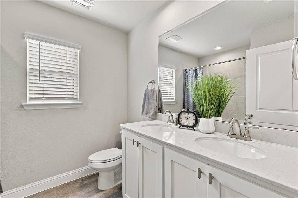 Dual vanity with undermount sinks, white cabinetry, and brushed nickel hardware