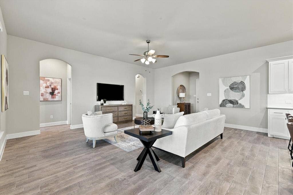 Open-concept living space featuring wood-finish flooring, recessed lighting, and an arched doorway