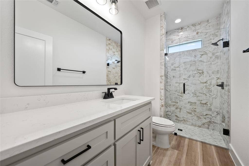 Shower with glass enclosure, white tile surround, and transom window