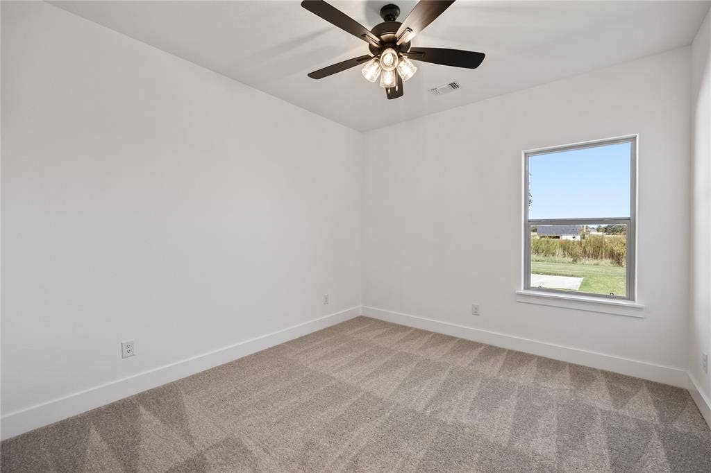 Neutral wall finishes, carpeted flooring, single window, and a ceiling fan with light fixture
