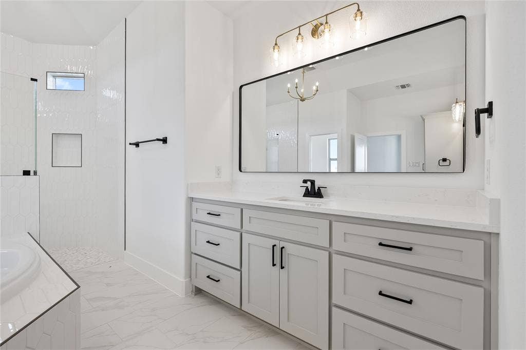 Dual vanity with light gray cabinetry, quartz countertop, and black hardware