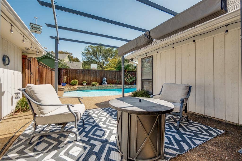 7414 Windmill Lane, Garland, TX 75044 Poolside patio featuring a pergola, string lighting, and wood fencing